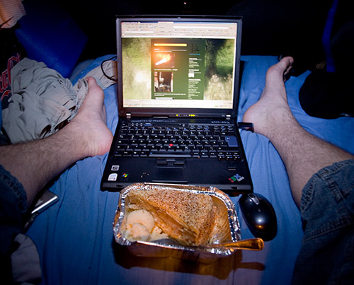 Füße, Laptop und Kuchen mit Vanilleeis